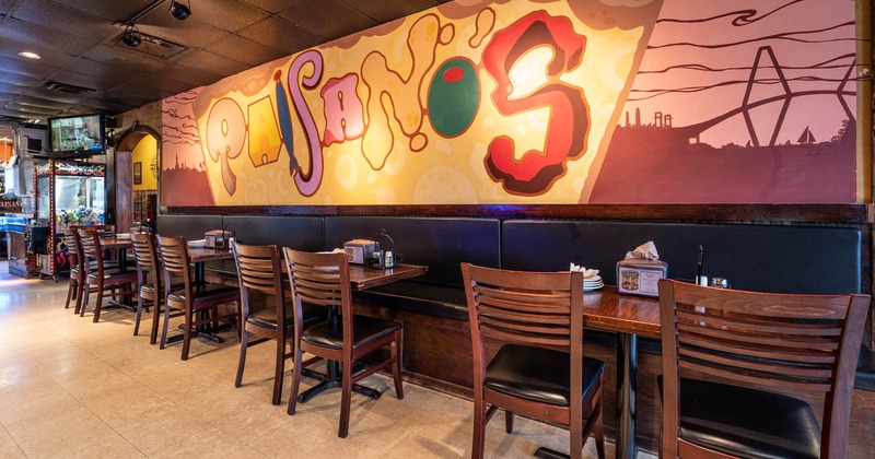 Interior, tables and chairs lined up, black leather high back benches