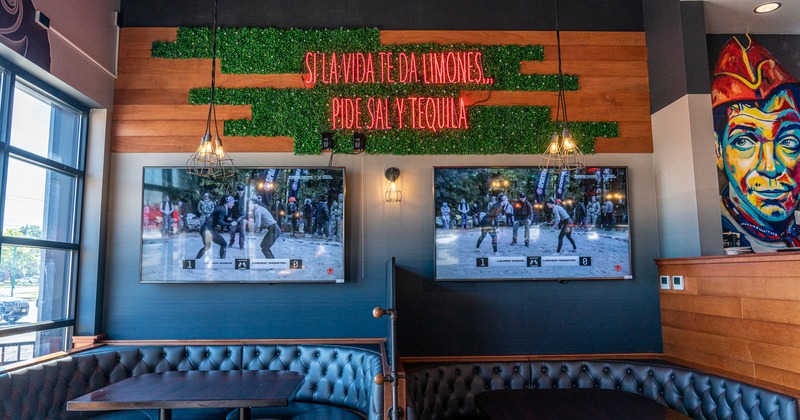 Interior, private seating area by a wall with decorations and two TVs