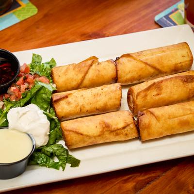 American taquitos served with lettuce and sour cream.