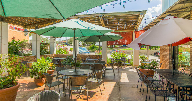 Outside seating area, green patio umbrellas over the tables