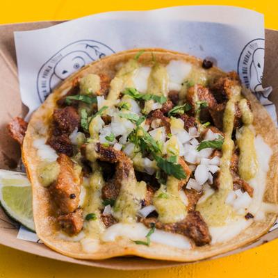 Carne Asada Taco topped with white onions, fresh cilantro, and a green sauce.