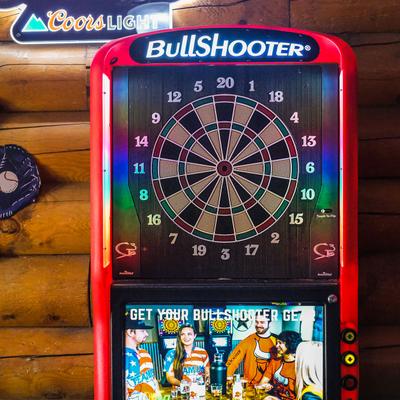Darts machine hanging on a wood wall