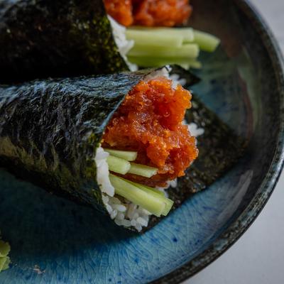 Spicy Tuna Handrolls on a blue plate, close up.