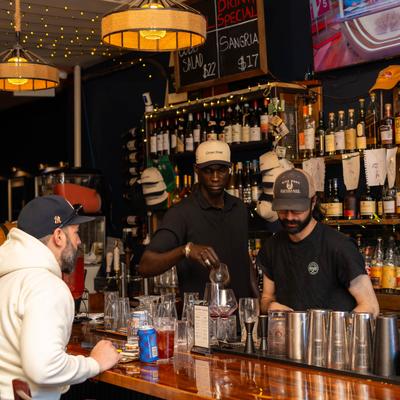 Bartenders preparing drinks behind the bar.