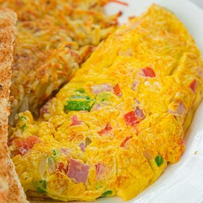 Denver omelet with ham and veggies, served with toast and hash browns.