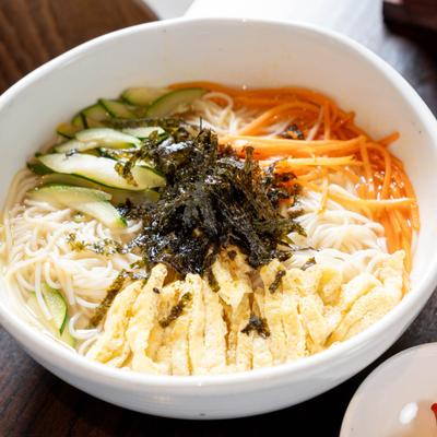 A bowl of noodles and veggetables.