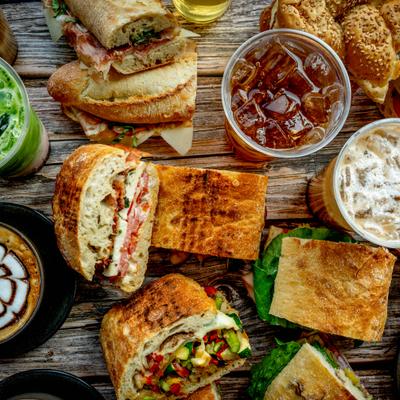 A catering lunch spread featuring a variety of sandwiches and beverages.