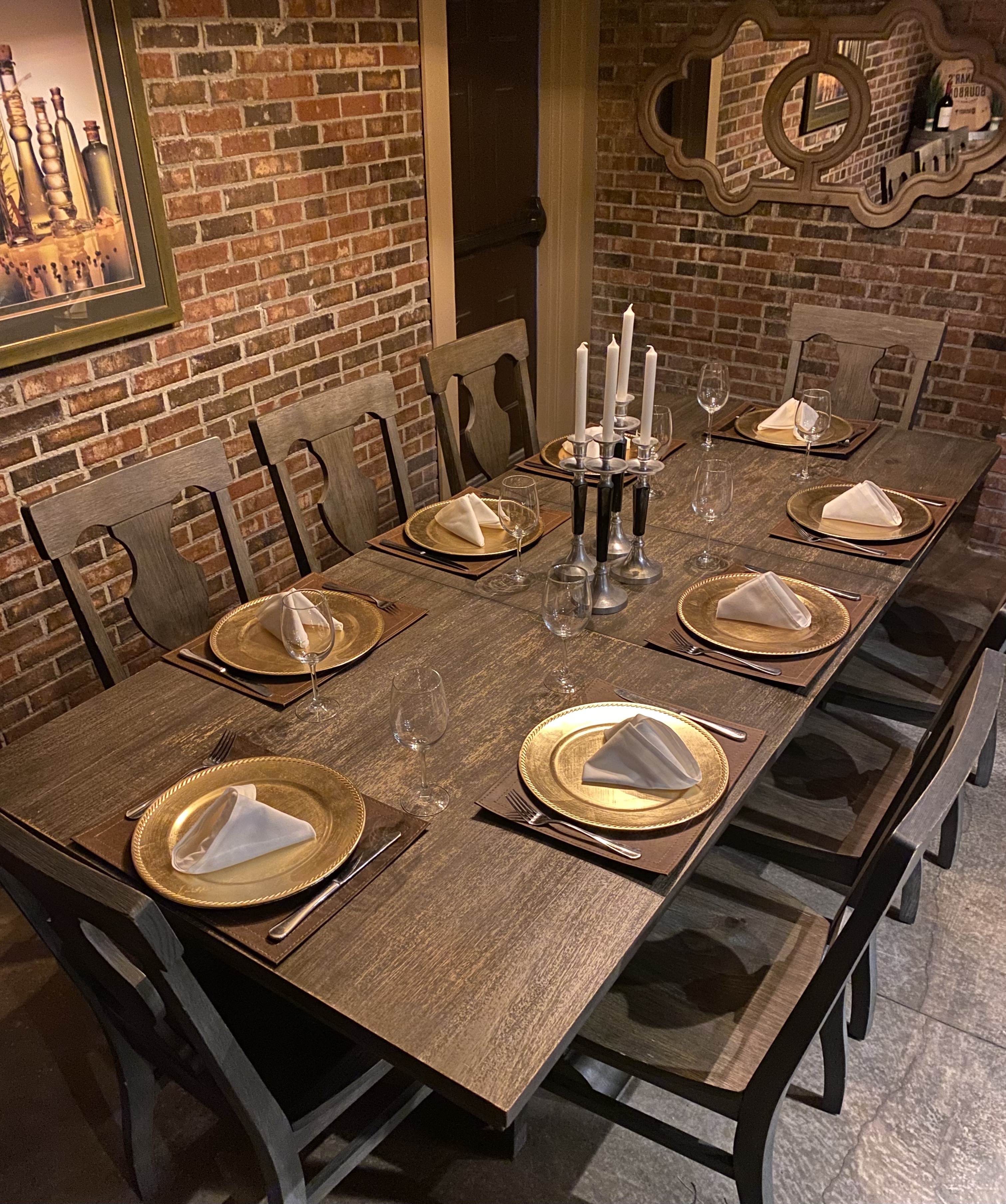a wooden chefs table set for dining at a restaurant in a dimly lit bricked room