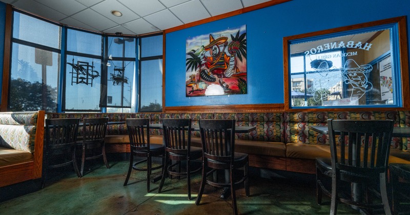 Interior seating area with booths, wooden chairs and tables