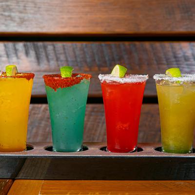 Assorted colorful cocktails glasses on a flight.