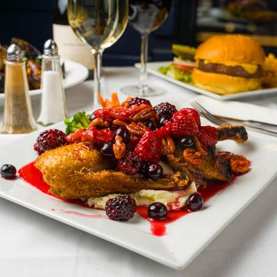 Crispy Peking Duck with fresh berries and macadamia nuts in a berry glaze.