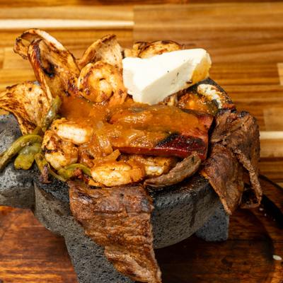 Grilled steak, chicken and shrimp in a stone bowl.