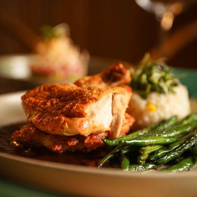 Pan-roasted half chicken with sweet corn rice and green beans, top view.