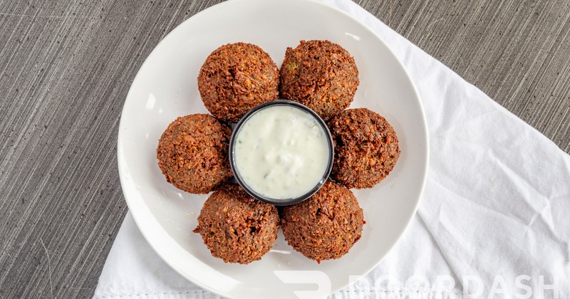 Gyro with hummus, shredded lettuce, red cabbage, cucumber, red onion and couscous
