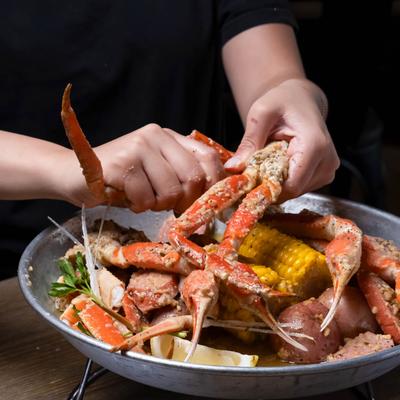 A person enjoying crab legs from the Crab set, dish close up.