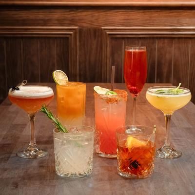 Assortment of cocktail drinks displayed on a wooden table.