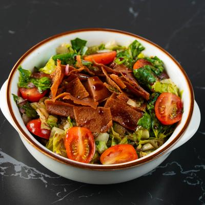 Lebanese Fattoush salad with mixed greens, cherry tomatoes, and  fried pieces of pita bread.