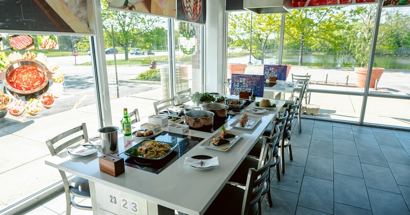 A modern dining table set with various Asian dishes and beverages