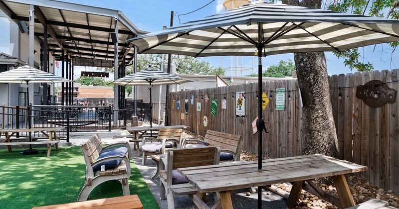 Courtyard with wooden table bench sets and garden umbrellas