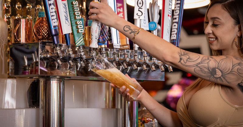 Female staff pouring beer from the tap