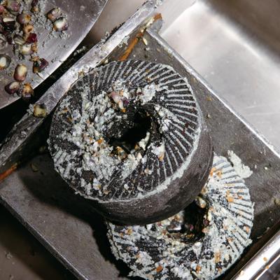 Close-up of a stone corn grinder coated with ground masa.