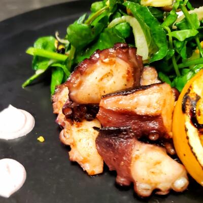 Grilled octopus served with a side salad.