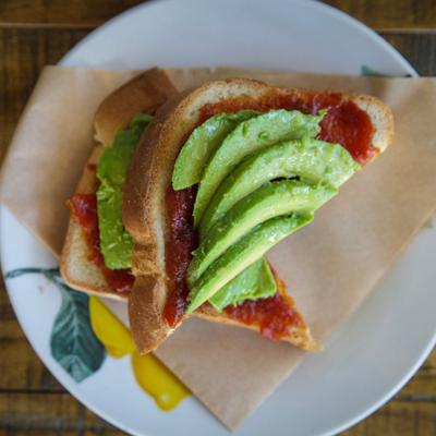 Avocado toast with tomato onion jam, ripe avocado and olive oil.