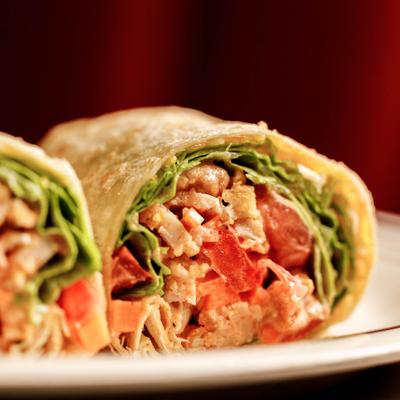 Chicken wrap filled with lettuce and tomato, closeup.