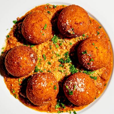 Crispy rice croquettes served over beef Bolognese sauce.
