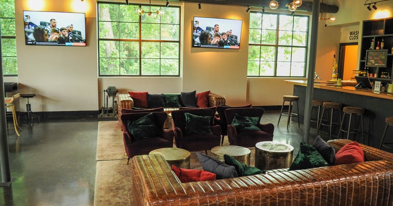 Interior, seating area with armchairs, sofas and coffee tables, TVs on the wall