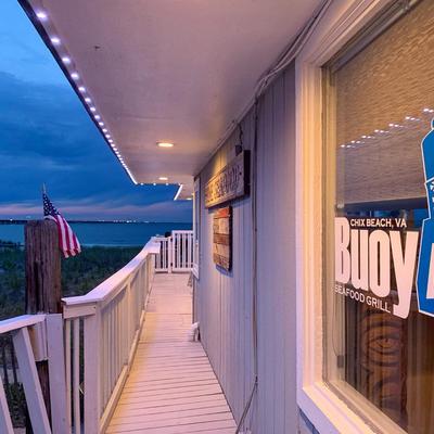 Restaurant waterfront deck and a window with a sign.