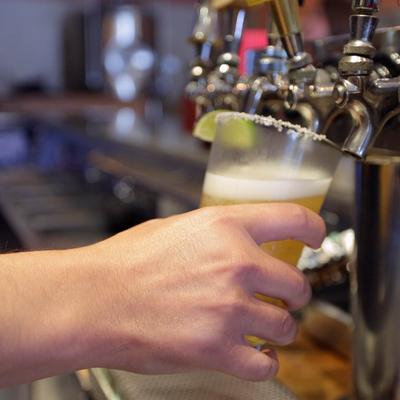 A hand holding a cup under the beer dispensary.