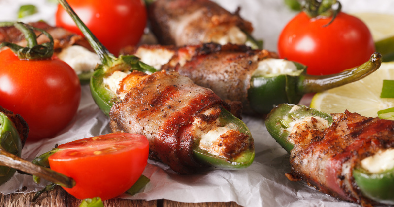 Bacon rolled and filled peppers and tomatoes on the side