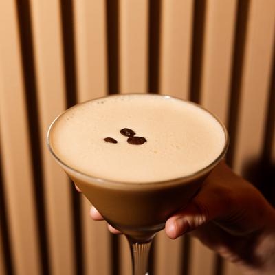 Espresso martini with creamy foam and coffee bean garnish.