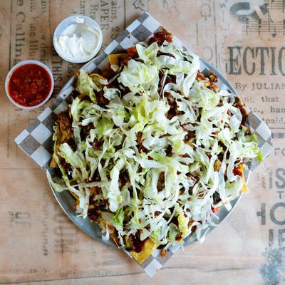 Nachos with pulled pork, cheese and lettuce, top view