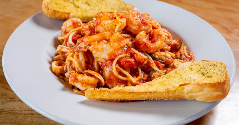 Spaghetti with shrimp in spicy sauce, served with toast