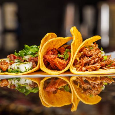 Mixed tacos served on soft corn tortillas with fresh onions and cilantro.