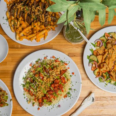 Spread of Middle Eastern cuisine presented on a wooden table, overhead view.