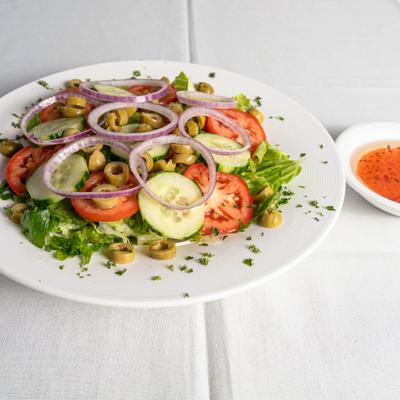 House Salad, with lettuce, tomato, cucumber, red onion, and olives.