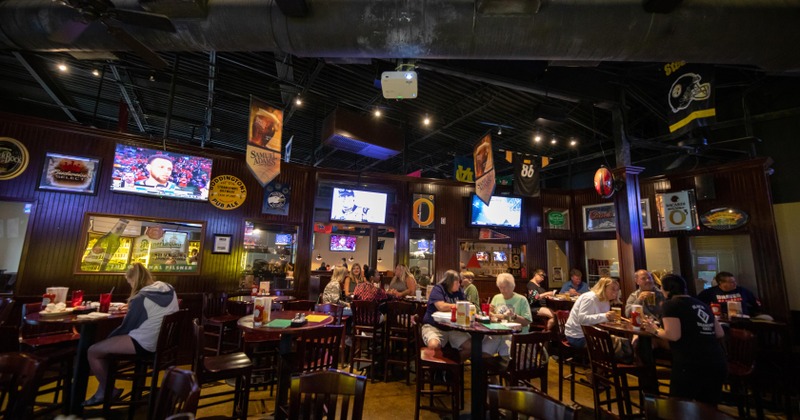 Interior, main seating area, lots of patrons and tv screens, cozy atmosphere