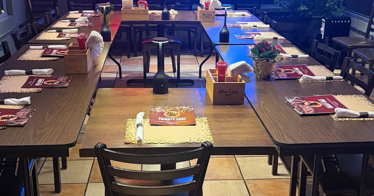 Long table setup for group dining and neon lights on the windows