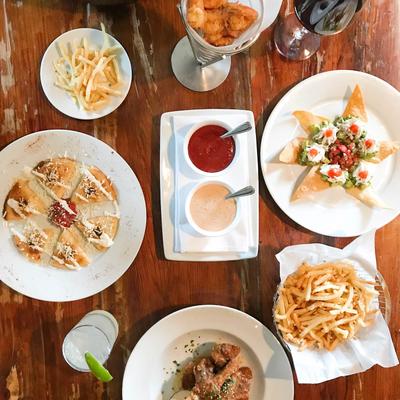 An assortment of various dishes and drinks spread on a table, overhead view.