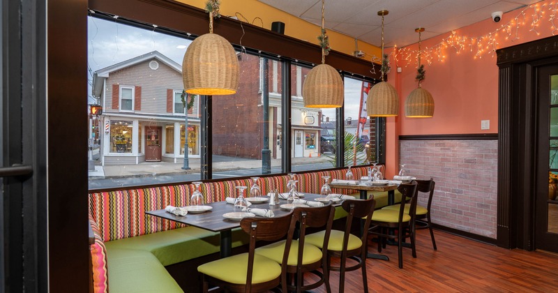 Interior, seating booths, set tables and chairs next to the windows