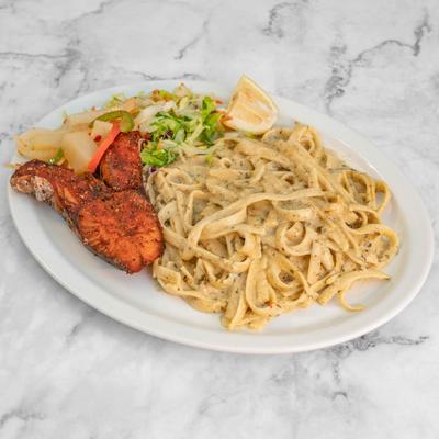 Fettuccine alfredo served with blackened fish, side salad and a lemon wedge.