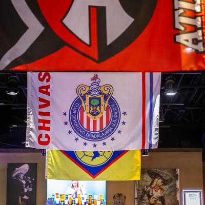 Soccer club flags hanging from the ceiling.
