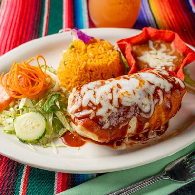 Beef burrito, served with rice, beans, and a salad.