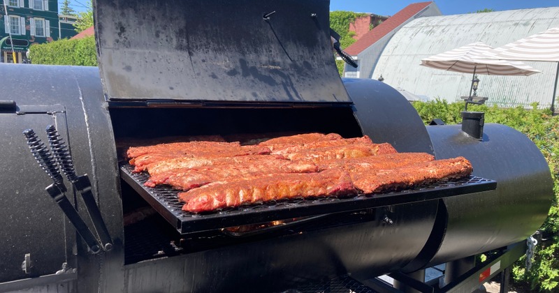 Racks of ribs cooking on an outdoor grill