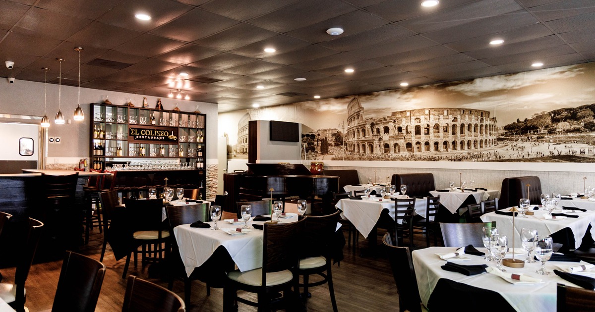 Interior of the restaurant with tables, a bar, and a mural on the wall