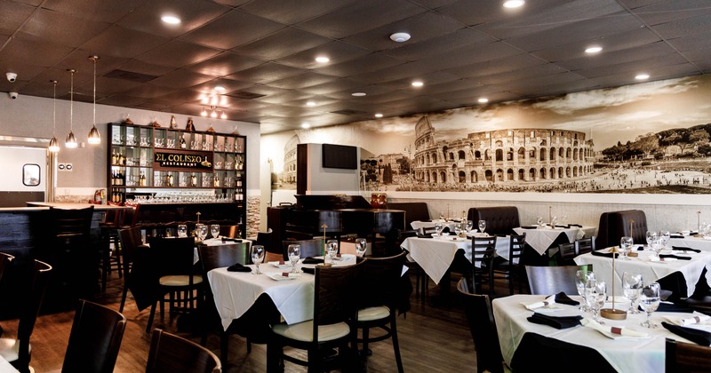 Interior of the restaurant with tables, a bar, and a mural on the wall