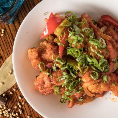 Indian butter chicken with sliced peppers and green onions.